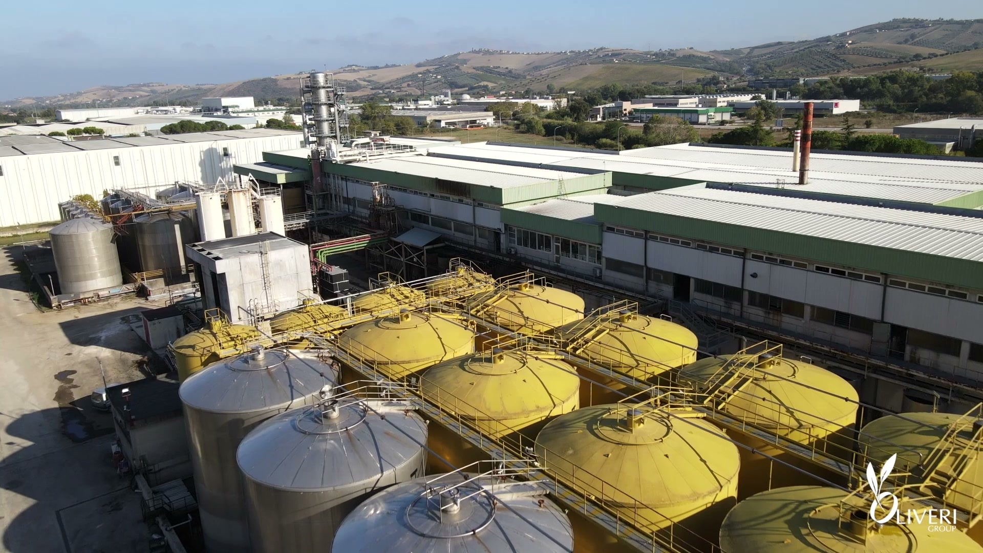 La raffineria Oliveri di Mosciano Sant'Angelo: i serbatoi e la colonna visti dal drone, il reparto, l'olio in laboratorio, i tappi sulla linea d'imbottigliamento; lo stabilimento del nocciolino, con l'essiccatoio, l'insacco e il robot dei bancali, e i bancali di nocciolino a Caltagirone
